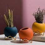 Macetas decorativas redondas con soportes metálicos geométricos