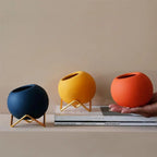 Macetas decorativas redondas con soportes metálicos geométricos