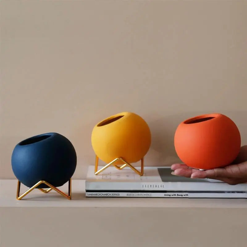 Macetas decorativas redondas con soportes metálicos geométricos
