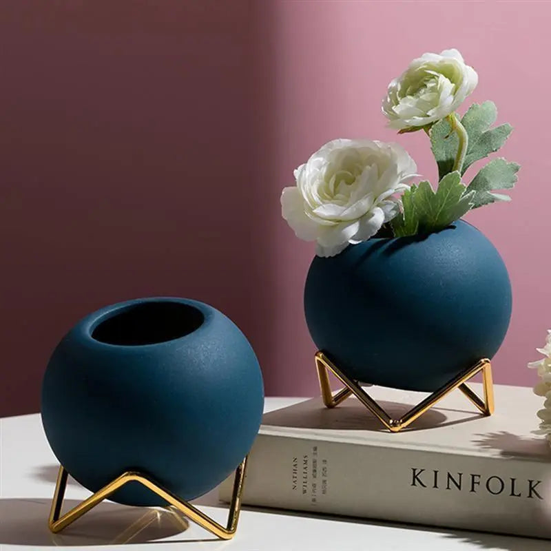 Macetas decorativas redondas con soportes metálicos geométricos