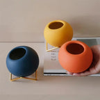 Macetas decorativas redondas con soportes metálicos geométricos