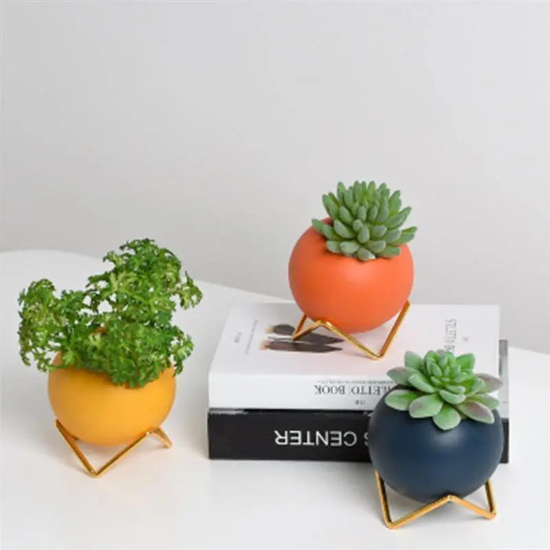 Macetas decorativas redondas con soportes metálicos geométricos