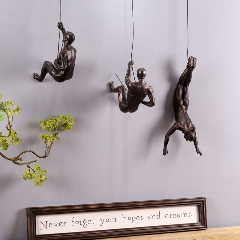 Motiverande väggskulptur med klättrande figur