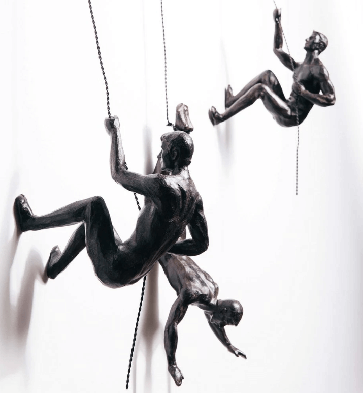 Motiverande väggskulptur med klättrande figur