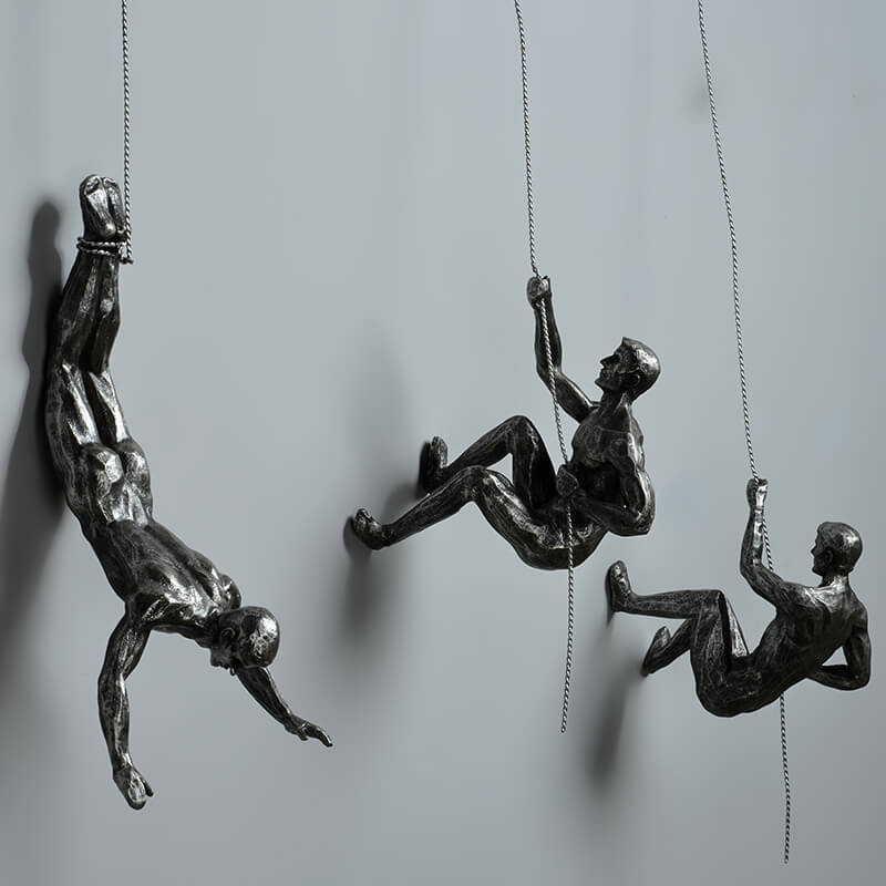 Motiverande väggskulptur med klättrande figur