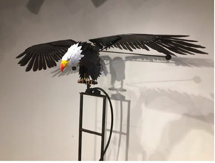 Metalowy wiatrak ogrodowy w kształcie ptaka na paliku, z ruchomymi skrzydłami