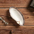 Handgefertigte Servierplatte aus Keramik in Muschelform mit strukturierter Oberfläche