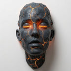 Skulptural LED-vägglampa med ansiktsmotiv och upplysta sprickor
