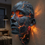 Skulptural LED-vägglampa med ansiktsmotiv och upplysta sprickor