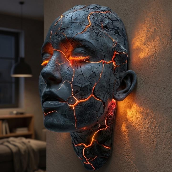 Skulptural LED-vägglampa med ansiktsmotiv och upplysta sprickor