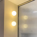 Minimalistisk vägglampa i frostat glas med mjukt stämningssken